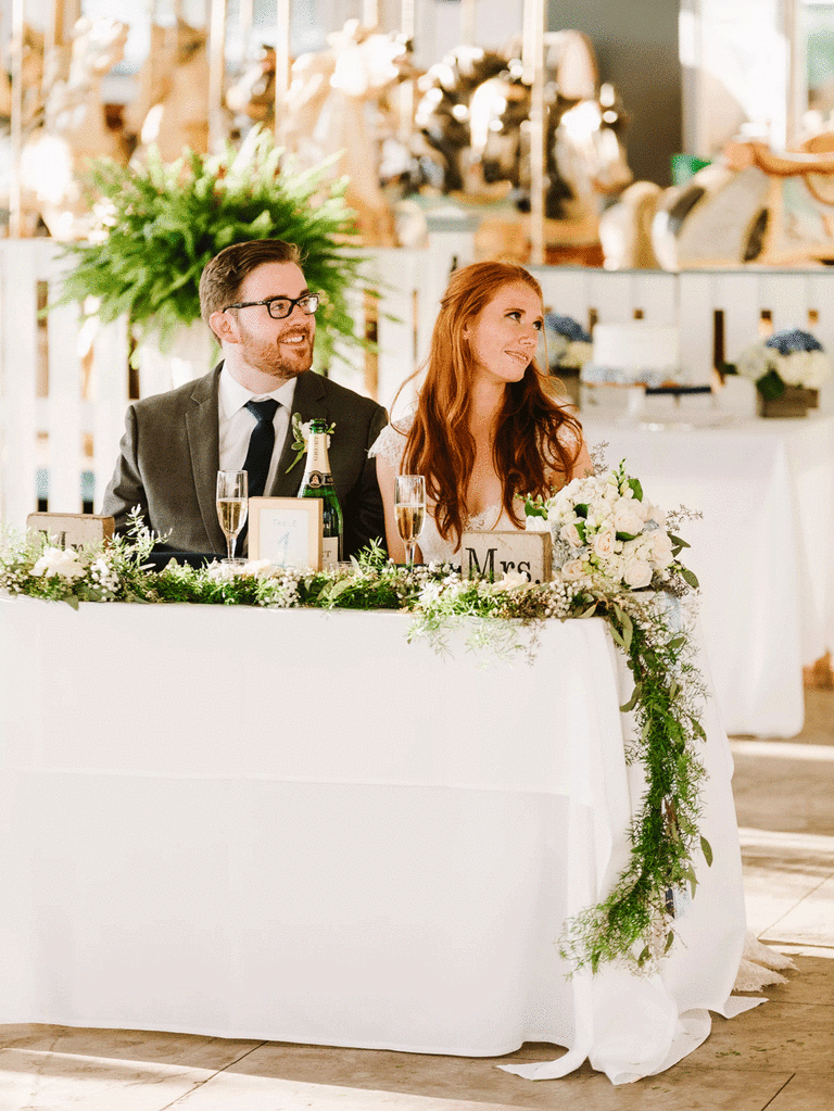 Couple at small sweetheart table at a wedding reception.