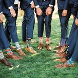 Groom and groomsmen wearing mismatched patterned wedding socks