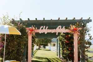 Bright Arch Welcome Sign With Couple's Names at Retro Desert Wedding