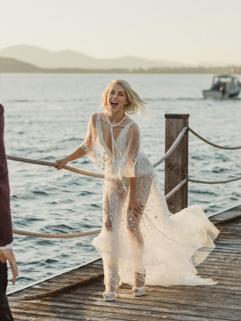 Julianne Hough smiles while wearing a stylish white reception dress. 