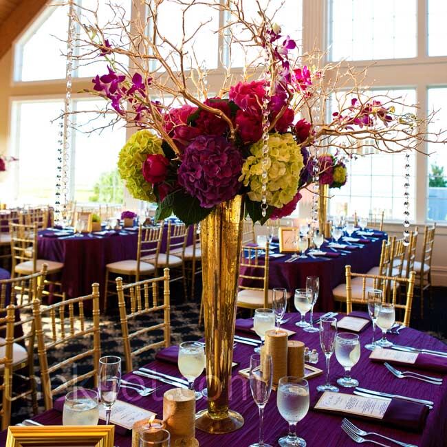 Gold mercury-glass vases and manzanita branches framed full arrangements of bold-hued hydrangeas and peonies.