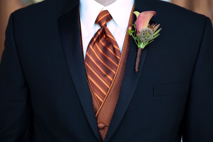 The groomsmen wore black tuxedos with striped burnt orange vests and ties.