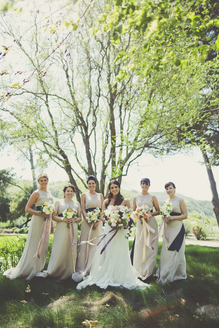 Lindsey’s bridesmaids wore long, neutral dresses with a navy ribbon tied around the wait.