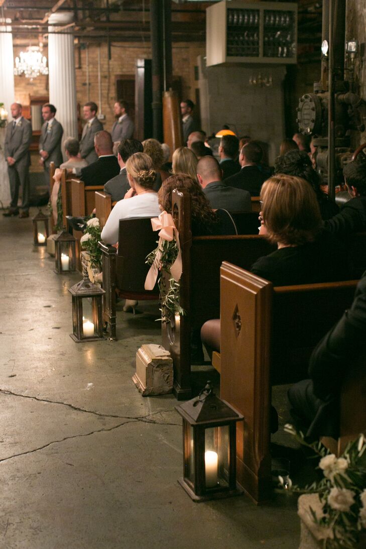 To set a romantic tone for the indoor ceremony, carriage lanterns filled with ivory pillar candles lined the aisle, casting a warm ambient glow over the room.