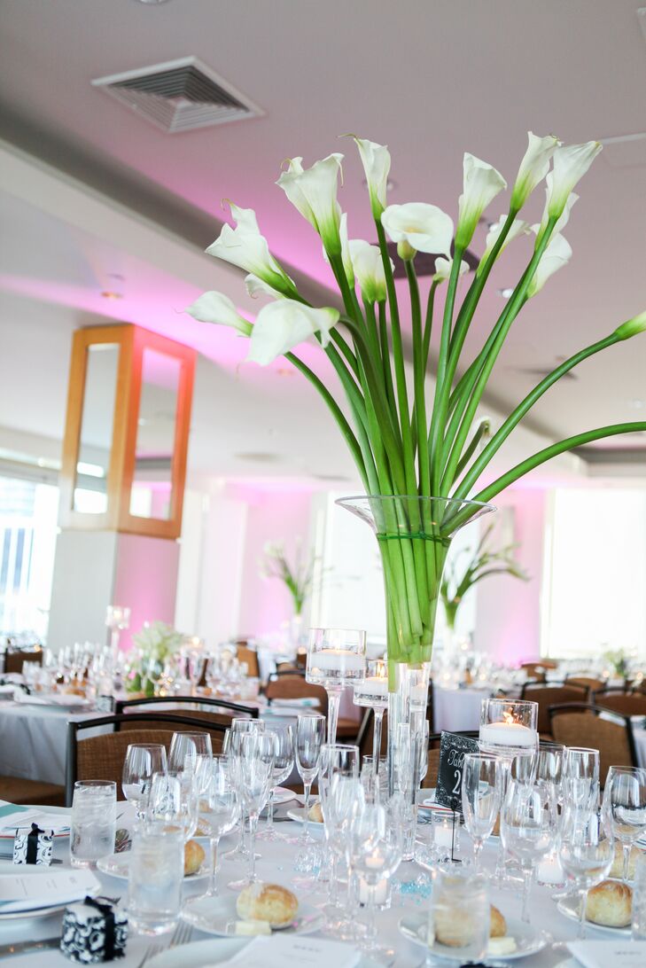 In typical theatrical style, the couple amped up the party lighting for their penthouse reception at Le Parker Meridien. Crisp white calla lilies sprouted out of tall glass vases on the dining tables and swirled in round vases on the head table to create an elegant, modern vibe.
