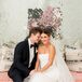 Bride and Groom Pose in Front of Reflective Wall on Pink Couch