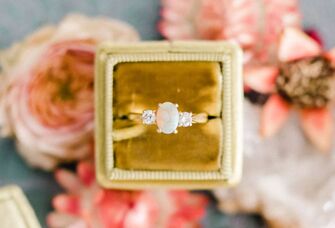 Diamond engagement ring in ring box on top of pink flowers