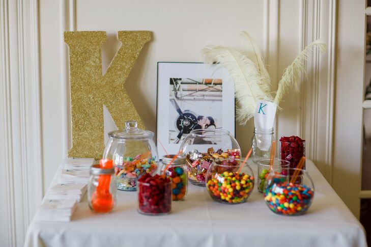 In addition to the classic wedding cake, a candy bar had all kinds of sweets and treats for guests to enjoy. A large "K" in gold sparkles and feathers decorated the back of the display, adding a touch of vintage style to the mix.