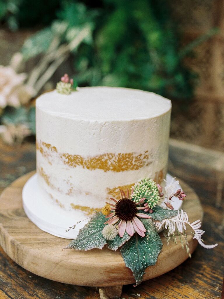 single-tier fall wedding cake with naked buttercream frosting and pink coneflower with greenery