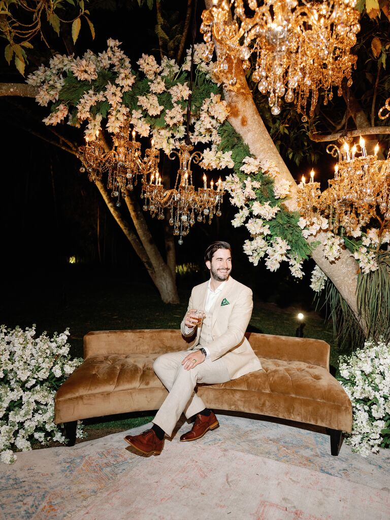 Influencer in Men's Wearhouse suit sitting on velvet sofa