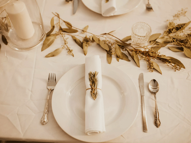 Bohemian place setting with neutral linens and leaf centerpieces.