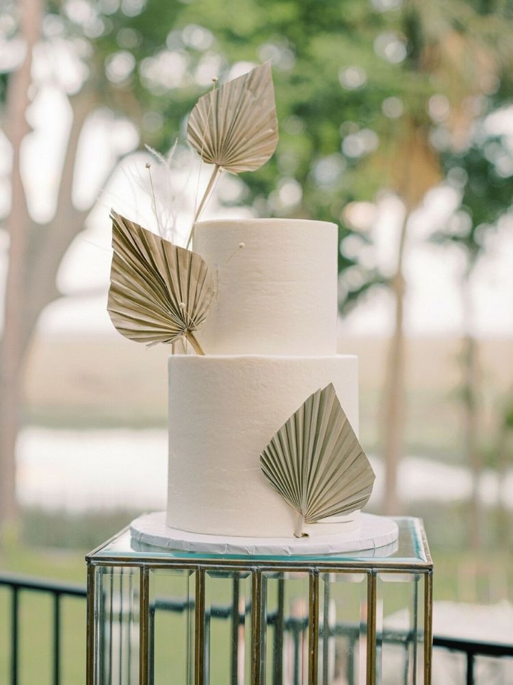 white wedding cake with gold leaves