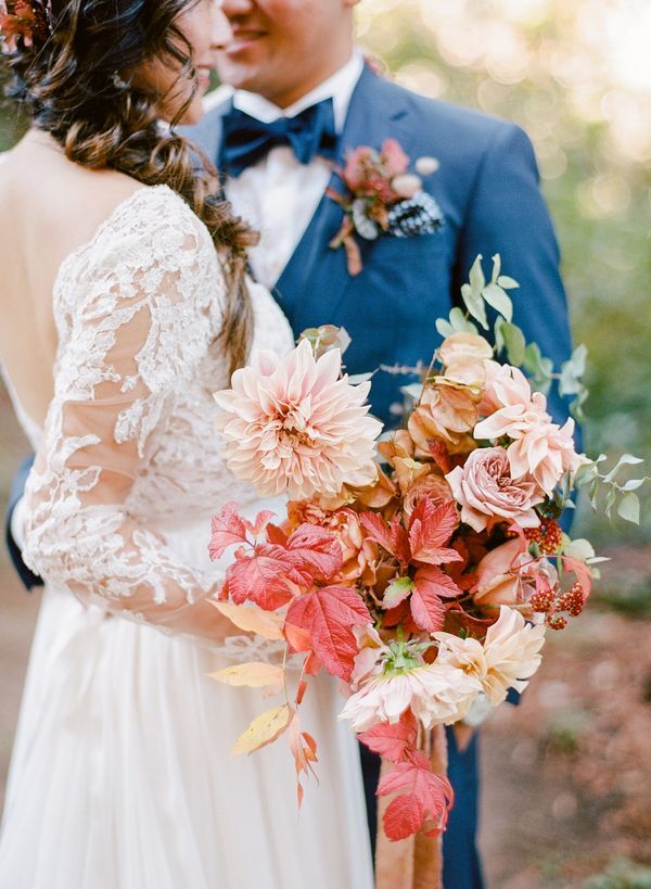 Bride hugging groom while holding fall wedding bouquet