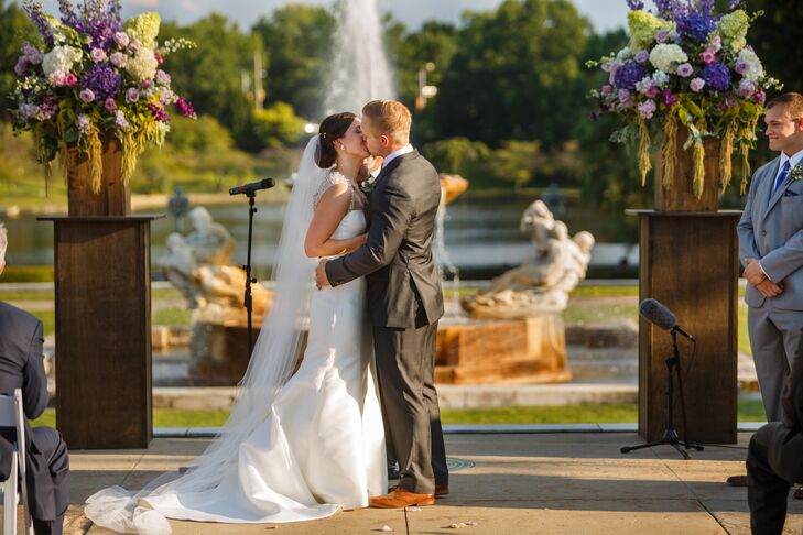 Jackie and Bryan shared their first kiss during the outdoor ceremony, with a beautiful backdrop of the lagoon and fountain on the property. Jackie's elegant silk wedding dress had a long train that trailed in the back, with her cathedral-length veil that blended in beautifully.
