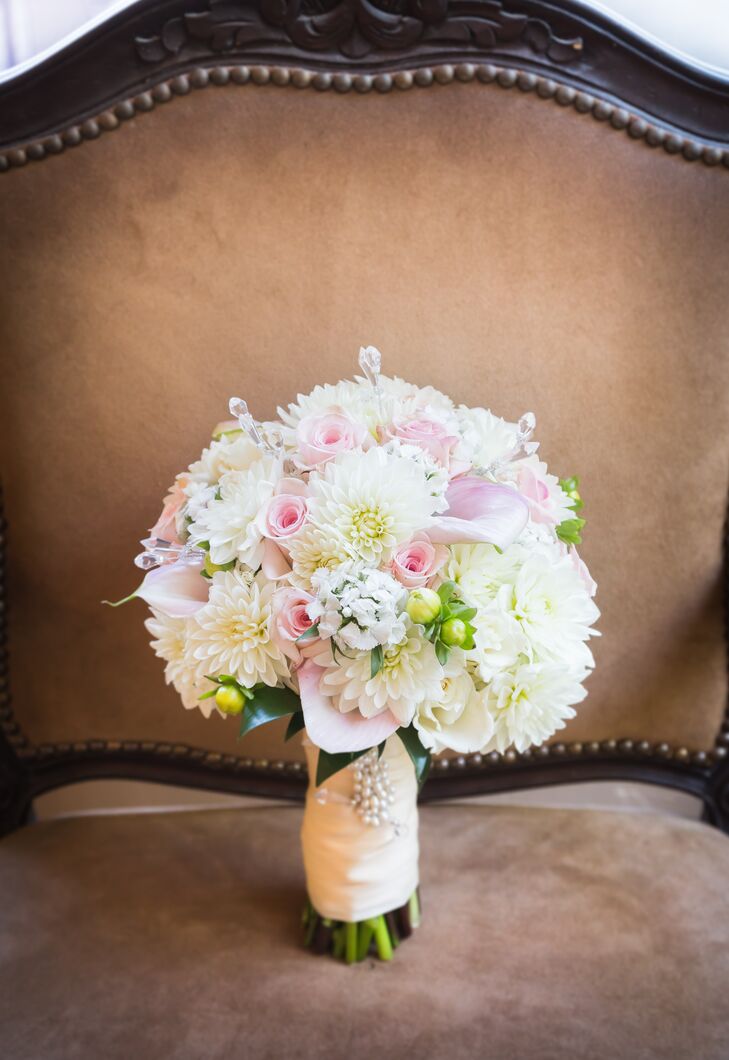 Marisa held a pastel-colored bouquet on the day of the wedding, which was filled with a combination of chrysanthemums, roses and calla lilies. The flowers were held together by a wrap accented with a white beaded pin.