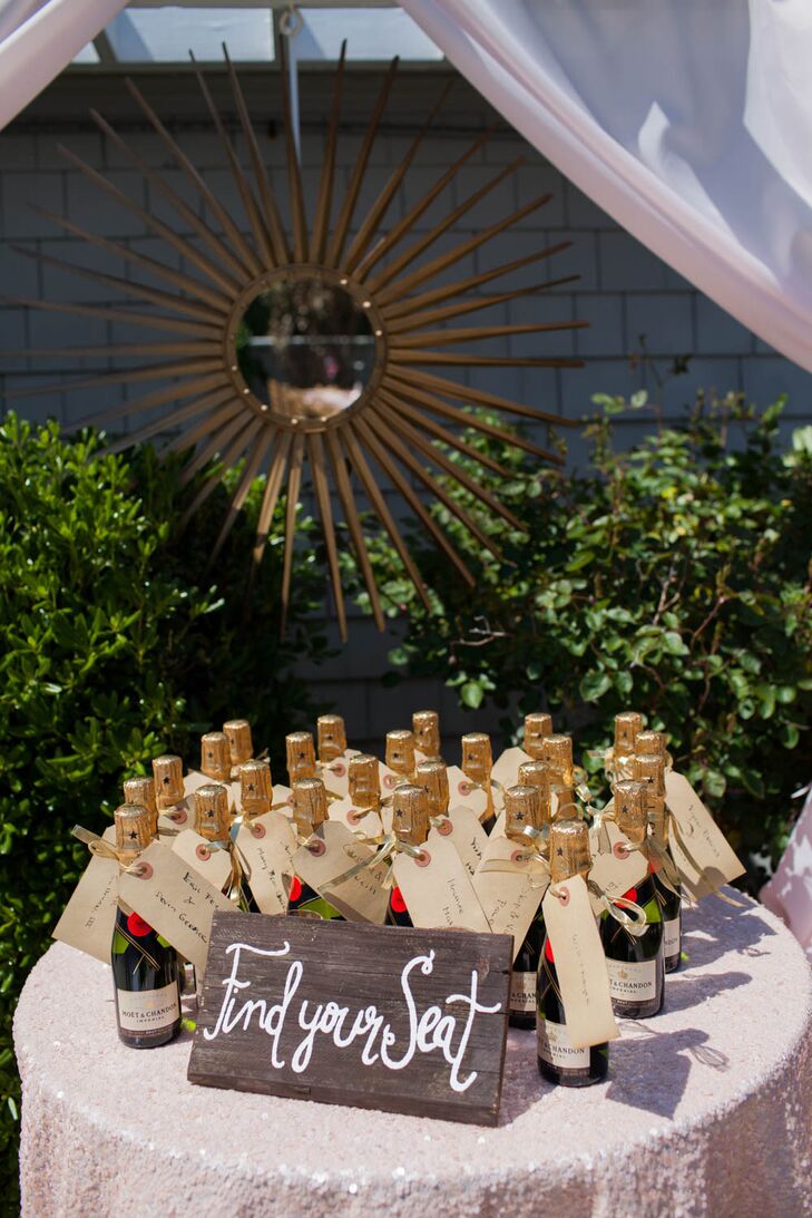 Instead of traditional escort cards, Ryan and Brian got the party started with Moet & Chandon champagne. They wrapped each bottle with a brown-paper tag tied with a gold ribbon. The couple handwrote each guest's name and table on the paper.
