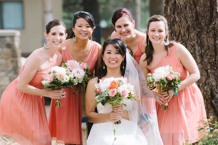 The bridesmaid wore short one-shoulder and v-neck dresses in a cheerful shade of coral pink.