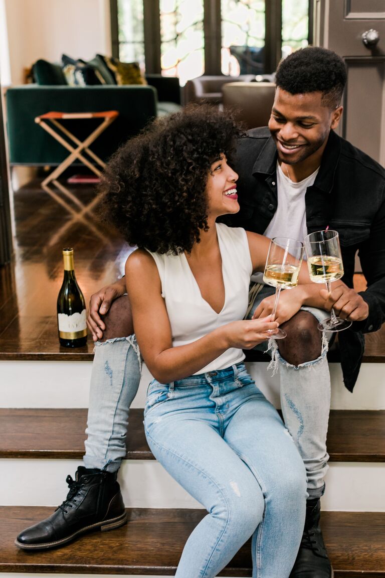 At-home engagement photo with white wine
