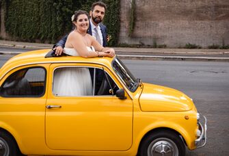 Couple standing thru sunroof of car