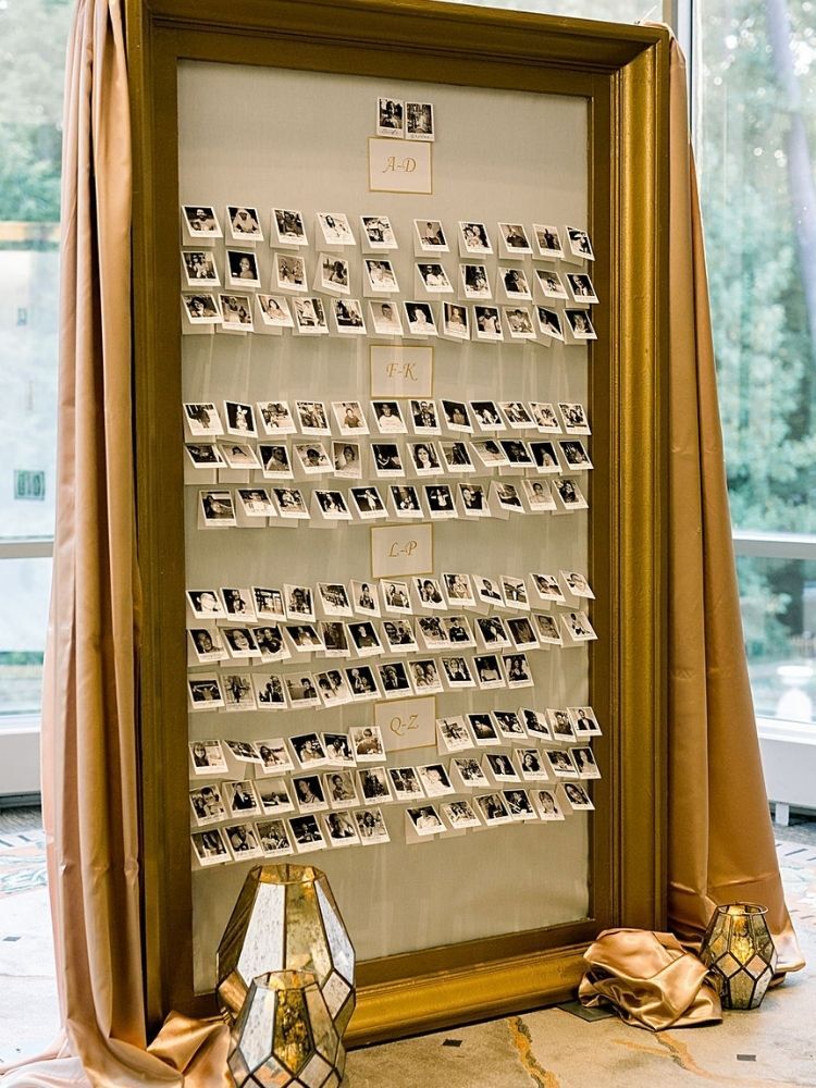 escort card wall with photographs of wedding guests
