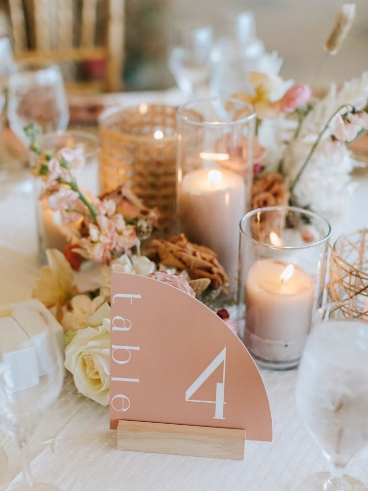 peach pillar candles and peach-hued table number sign