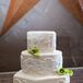 The wedding cake and groom’s cake were made by Whisk Until Sweet, a family friend of the couple’s. “They turned out simply delicious,” Rebecca says. The wedding cake featured three ivory tiers, with a center tier covered in a white lace pattern with fondant green calla lilies.