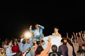 Couple Being Hoisted in Chairs During Hora at Jewish Wedding Reception