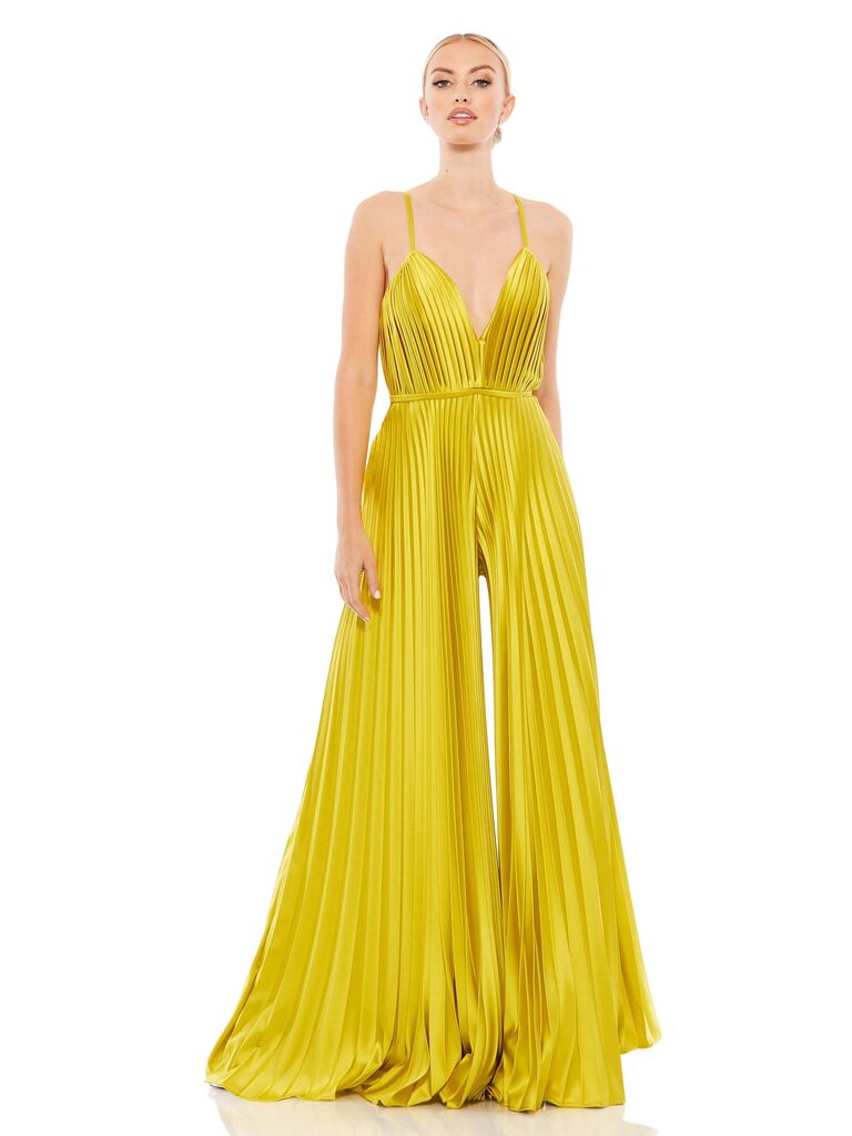 Model wearing a Chartreuse jumpsuit with spaghetti straps and pleated accents