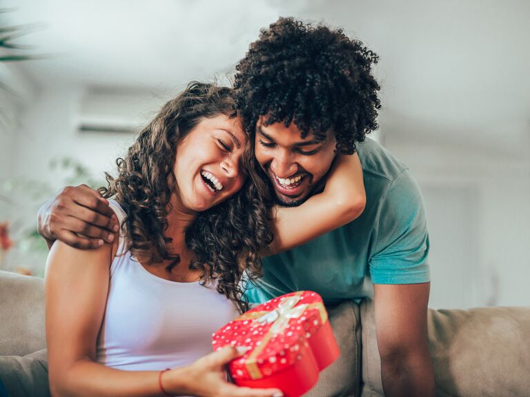 Couple smiling and holding a just because gift