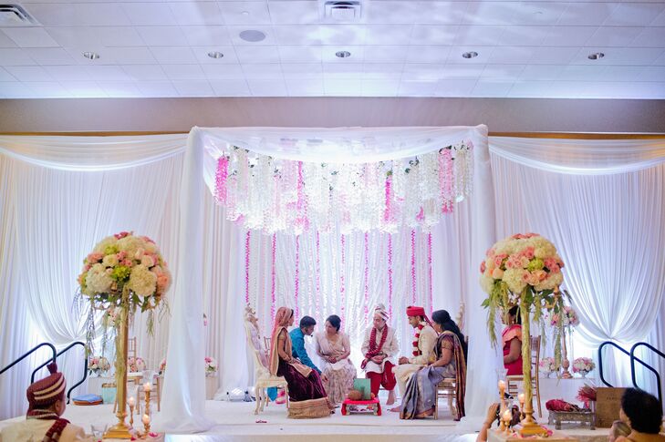 Wanting the wedding to have an ethereal romantic feel, the couple, with the help of planner Zeena Roy of Oliveaire, designed a showstopping mandap that served as the focal point for the ceremony. The stunning construction featured light, airy panels of white fabric and cascading pink and white orchid garlands that introduced an air of whimsy to the Westin Lombard’s ballroom.