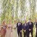Linda's bridesmaids wore dresses of their choice in shades of blush and carried small pink bouquets. The groomsmen wore their own navy suits and blue bow ties.