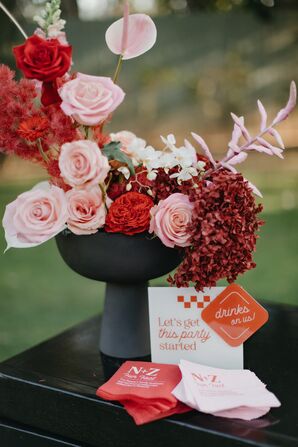 Red Flower Arrangement With Roses in Black Vase