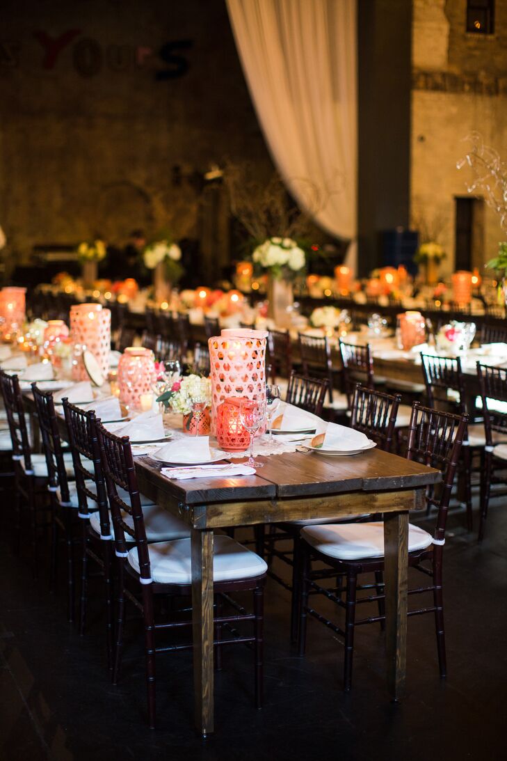 To create a casual feel at the reception, Molly and Boston used long farm tables for their guests. Pink lanterns, which were also used to line the ceremony aisle, decorated the tables along with short flower arrangements and plenty of candles.
