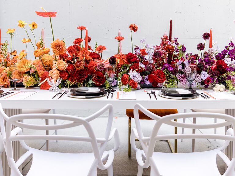 white table and chairs with bright rainbow flower table runner