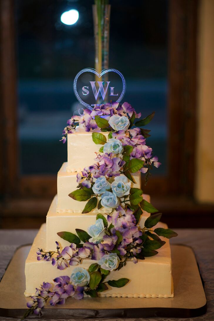 Lacey and Sara enjoyed a a four-tier white buttercream cake decorated with gorgeous blue roses and purple hydrangeas cascading down the front.