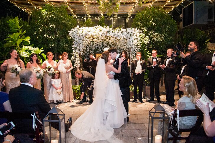 Planterra Conservatory in West Bloomfield, Michigan, provided the gorgeous arbor of white flowers over the altar. After the kiss, a gospel choir broke into a lively rendition of “Oh Happy Day."