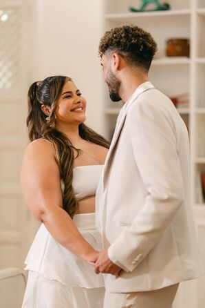 Bride in Half Up Hairstyle, Two-Piece White Outfit and Groom in White Suit