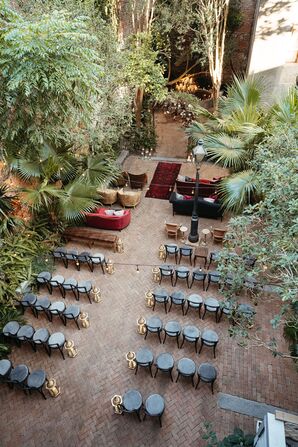 Courtyard Ceremony Aisle, Black Chairs and Lounge Furniture Under Trees, Greenery