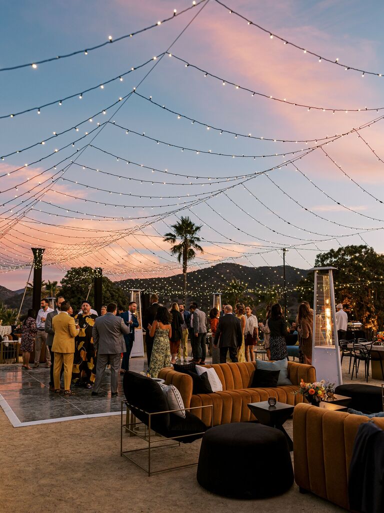outdoor wedding reception with string lights draped into a tent shape above the dance floor
