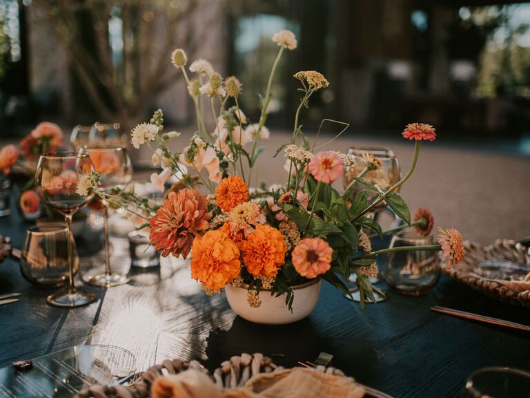 Bohemian orange wildflower wedding centerpieces on reception tables