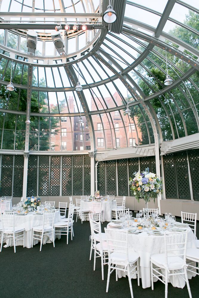 Alexandra and Will's whimsical vintage inspire wedding reception took place in the Palm House at the Brooklyn Botanic Garden and was decorated with white round tables, white chiavari chairs and floral centerpieces of roses, peonies and hydrangeas in alternating heights.