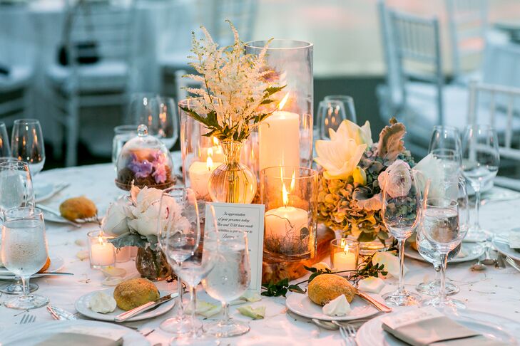 Alexandra and Will's wedding florist, Rebecca Shepherd Floral designs, decorated the reception table centerpieces with various flowers, including roses, peonies and irises, and warm candlelight. "She used bell jars and antique candlesticks to add to the centerpieces," Alexandra says.