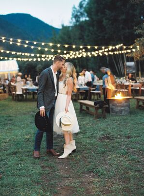 Bride in Short White Dress and Groom in Jeans, Cowboy Boots, Hats Kiss Under String Lights