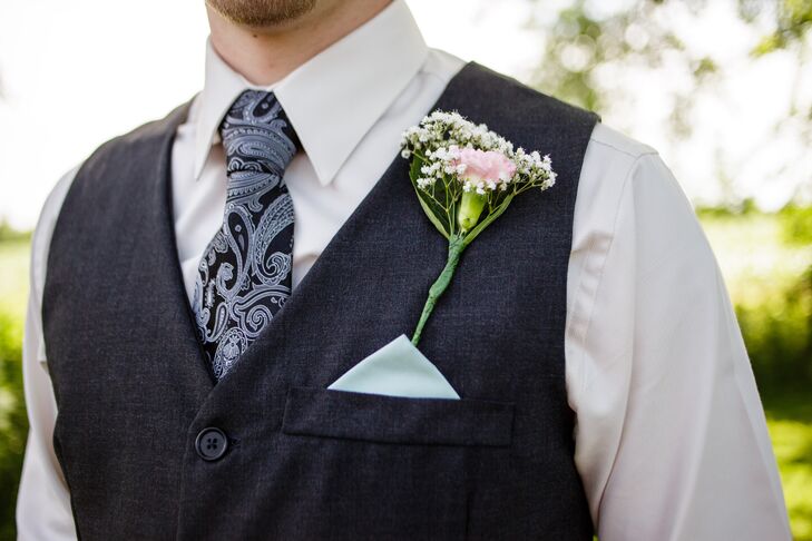 Eric had a single pink carnation mixed with baby's breath as his boutonniere, pinned to his black vest that had a mint green pocket square tucked in. He wore a blue paisley-patterned tie over his white collared dress shirt, while his groomsmen wore mint ties.