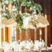 Groom in Tuxedo Kissing Bride in Two-Piece White Outfit, Tulle Skirt and Veil