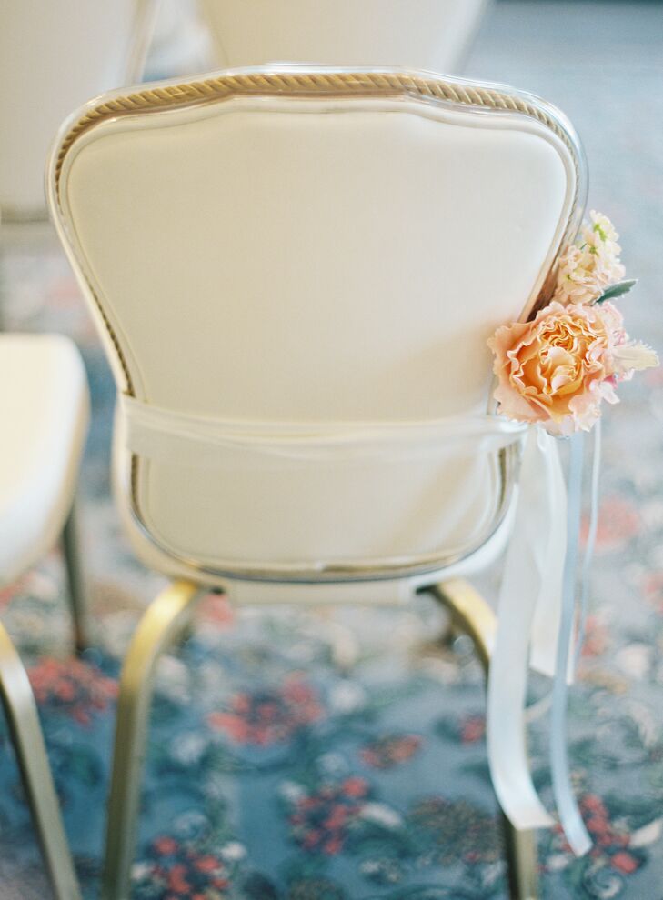 With a whimsical floral huppah serving as the focal point of the room, Alyse and Dimitry decided to keep the rest of the ceremony decor to a minimum. The couple had The Special Event Florist create small bundles of peach and coral peonies to line the aisle, an understated touch that introduced a hint of color and romance to the elegant ballroom.