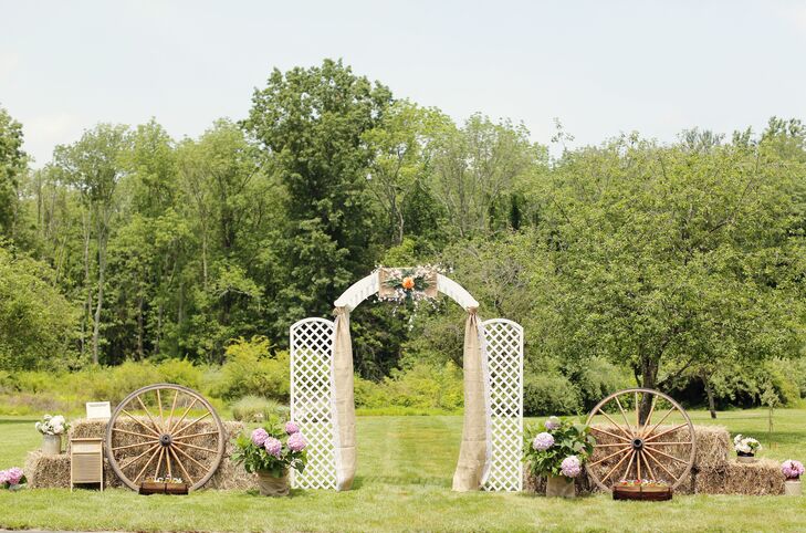 Kathleen and Kenny exchanged their vows in true country style, under a ceremony arch draped in burlap, which was surrounded by hay bales and wagon wheels.