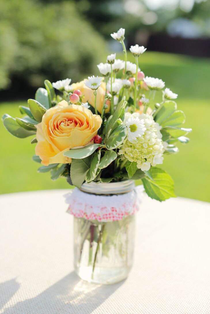 Peach roses mixed with a blend of white flowers in mason jars created simple, country-inspired centerpieces for the cocktail-hour tables.