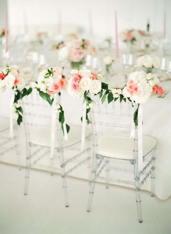To distinguish their seats at the head table, Mia and Jake had Celadon and Celery Events create floral garlands for their ghost chiavari chairs. Featuring blush roses, white hydrangeas and greenery, the arrangements achieved a whimsical, garden feel.