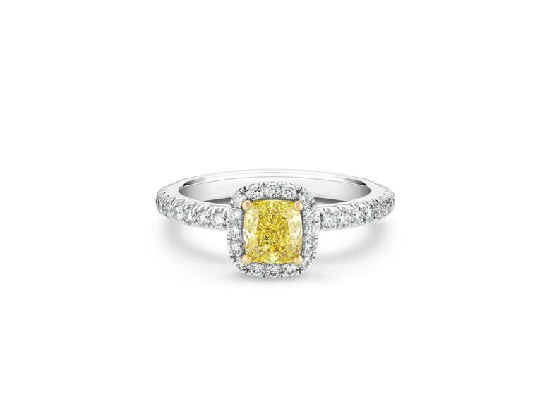 debeers cushion cut yellow diamond engagement ring with yellow gold claw prongs round diamond halo and diamond encrusted white gold band